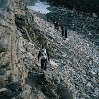 A hiker climbing upward along a mountain trail.