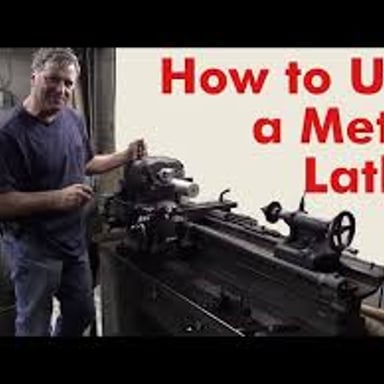 A machinist operating a metal lathe in a workshop.