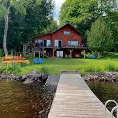 Small vacation cottages beside a calm lake.