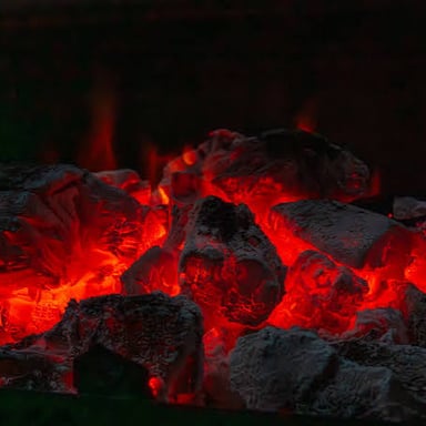 Red-hot coals glowing in a fire.