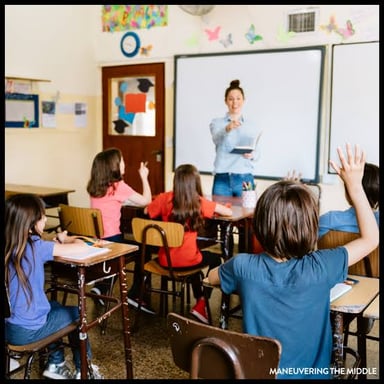 A teacher speaks sternly to a student in a classroom.
