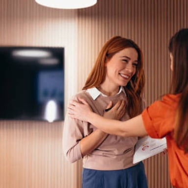 A person smiles and congratulates a colleague.