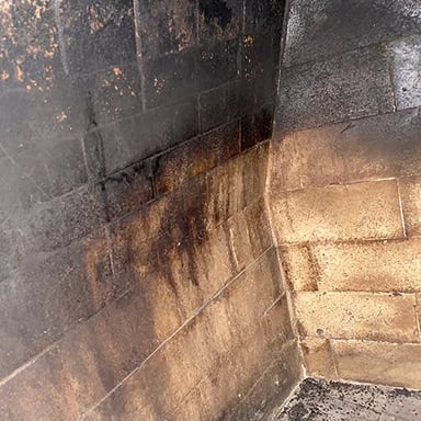 Black soot coating the inside of a chimney flue.