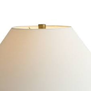 A table lamp with a fabric shade surrounding its bulb.