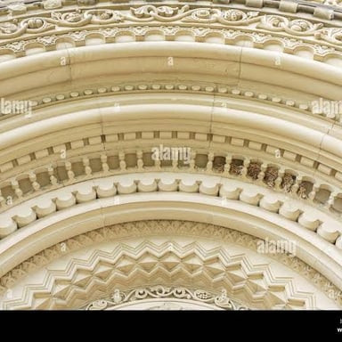 A close view of finely carved ornamental molding on a building.