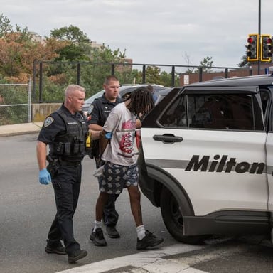 A police officer placing handcuffs on a detained person