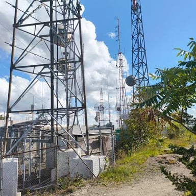 Several antennas are mounted near the top of a broadcast tower.