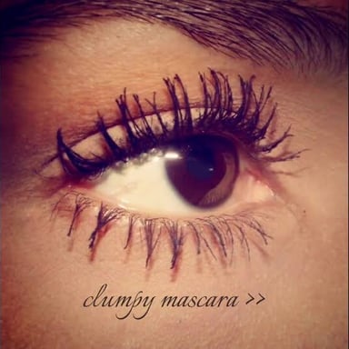 Close-up of eyelashes with mascara gathered into visible clumps