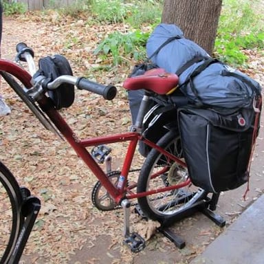 A bicycle fitted with a pannier beside its rear wheel
