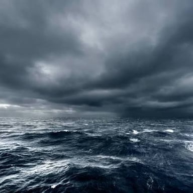 Dark storm clouds hang over rough sea.