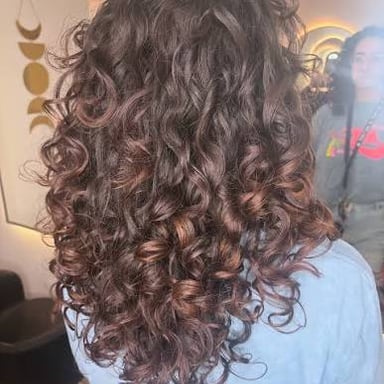A close-up of large, soft curls with a springy appearance.