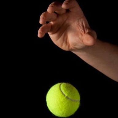 A person loses their grip on a ball as it falls.