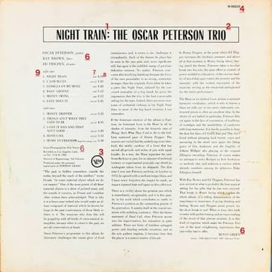 A vinyl record beside an album sleeve showing a track listing.