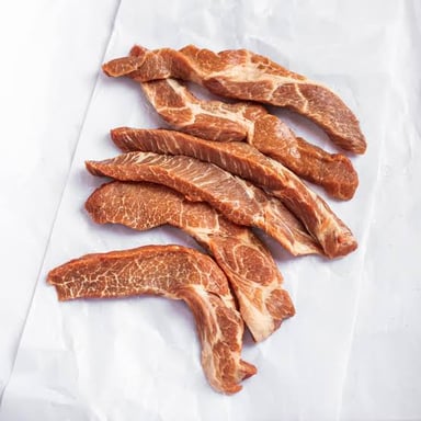 Small trimmed boneless pork rib cuts displayed by a butcher.