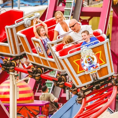Passengers riding a steep roller coaster at an amusement park.