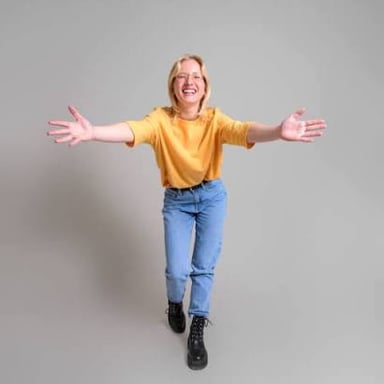 A person welcomes another with their arms open.