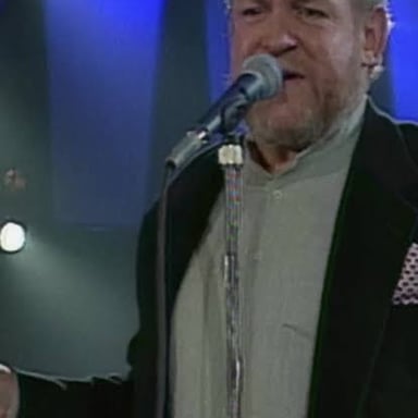 Joe Cocker performing onstage with a microphone.
