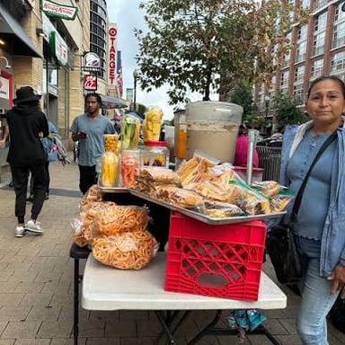 A street vendor selling goods at a market stall.