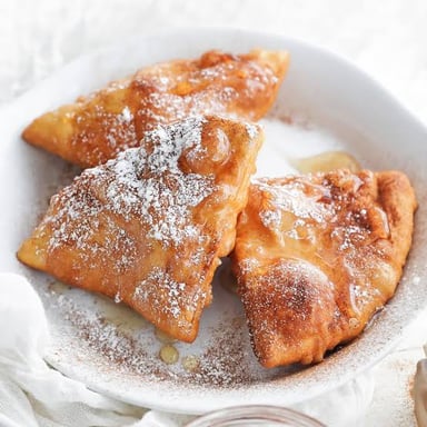 Golden fried sopaipillas served on a plate.