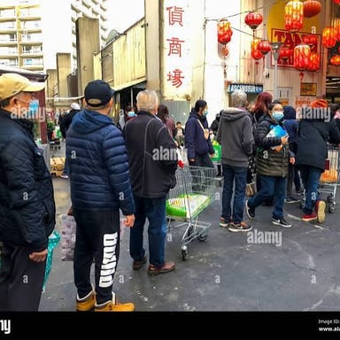 People waiting in an orderly line outside a shop