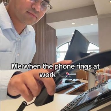 A ringing phone interrupts a person working at a desk.