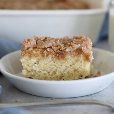 A small piece of coffee cake broken off beside a slice.