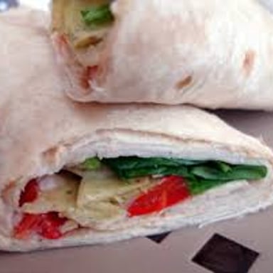 Rolled flatbread wraps filled with vegetables and chicken.