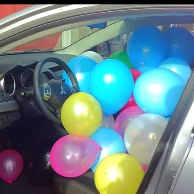 Colorful balloons filling the inside of a car as a practical joke.