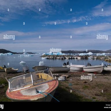 Boats moored in a sheltered harbor beside a dock.