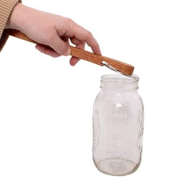 A tool being used to pry open a lid, illustrating the literal sense of “pried.”