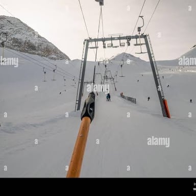 Skiers being pulled uphill by the T-shaped bar of a T-bar lift.