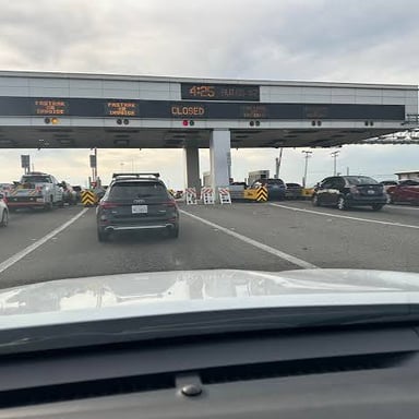 A car approaches toll lanes on a highway.