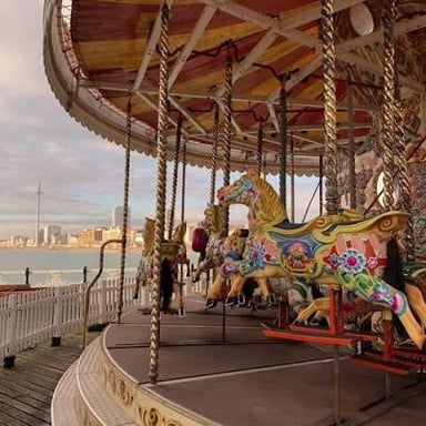 A carousel turns with painted horses beneath its canopy.