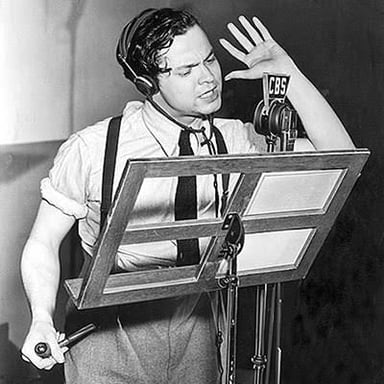 Actors recording a radio drama around studio microphones.