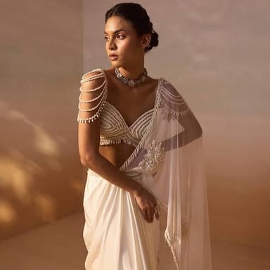A person wearing a traditionally draped South Asian sari.