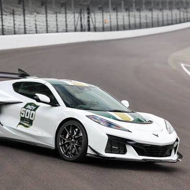A pace car leading race cars around an oval track