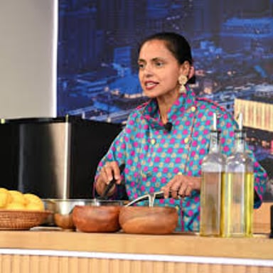 A chef preparing food and demonstrating a recipe in a studio kitchen.