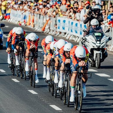 A group of cyclists racing along a road during the Tour de France.