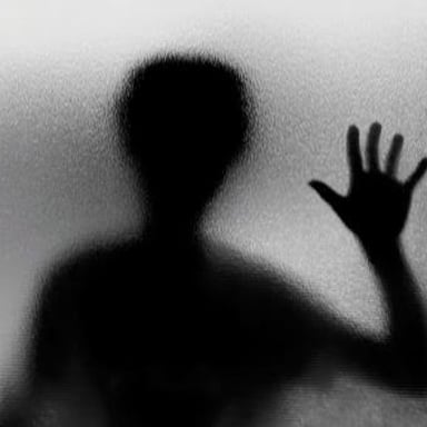 A shadowed person conveying a suspicious or secretive appearance