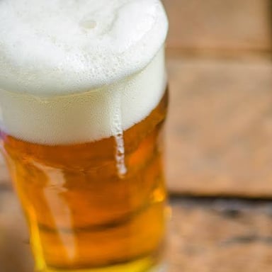 A glass of golden, foamy session IPA.