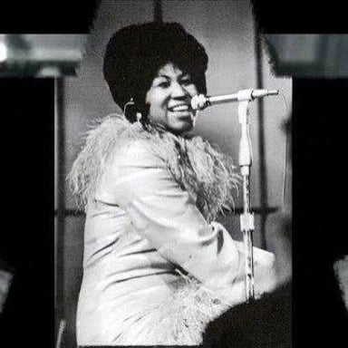Aretha Franklin performing onstage with a microphone