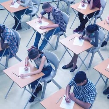 A student works through a standardized exam at a desk.