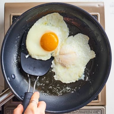 Two over-easy eggs, lightly fried on both sides with their yolks still runny.
