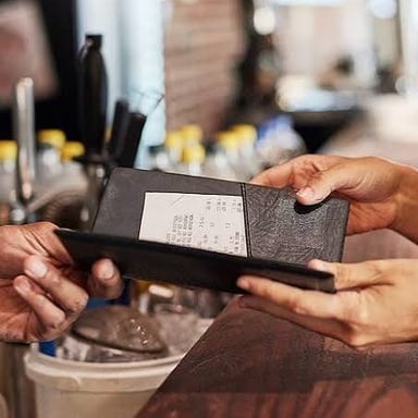 A person offering to pay a restaurant bill