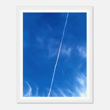 An airplane leaving a white contrail across the sky