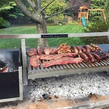 Meat cooking over embers on a parrilla during an Argentine asado.