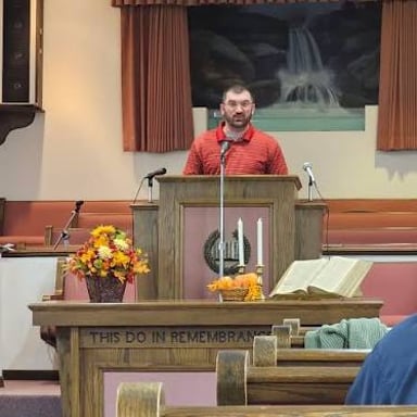 A pastor leading a religious service from a pulpit.