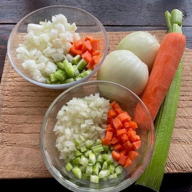 Diced onions, carrots, and celery prepared together as mirepoix.