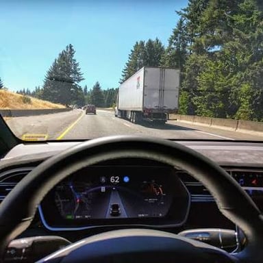 A passenger car on a road, representing a vehicle that may have self-driving features.