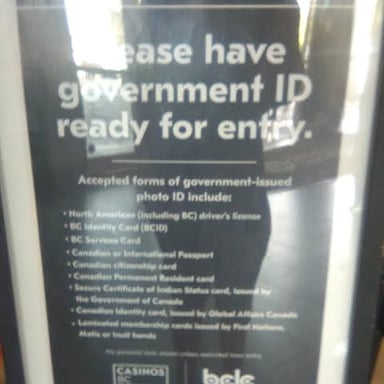 A person showing an identification card at a casino entrance.
